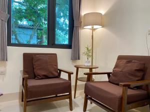 a waiting room with two chairs and a lamp at Literature River Bank 文學河岸 禁菸小包棟民宿 in Hualien City