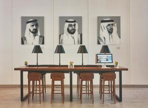 a table with chairs and a computer on top of it at Rove City Centre, Deira in Dubai