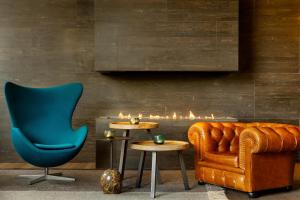 a living room with a couch and a chair at Motel One Edinburgh-Royal in Edinburgh