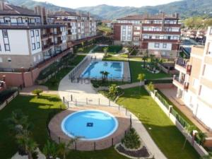 an apartment with a large swimming pool in a city at BAKIO BEACH in Bakio