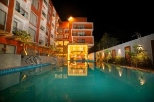 een zwembad voor een gebouw 's nachts bij Abhyagama Hotel in Digha