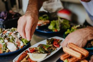 a person reaching for a plate of food on a table at Les Toues Cabanées du lac in Le Sauze-du-Lac +16 photos