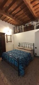 a bedroom with a bed with a blue bedspread at Casa La Fornace in Fornacette