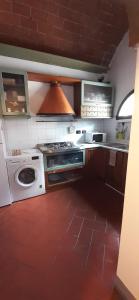 a kitchen with a stove and a washing machine at Casa La Fornace in Fornacette
