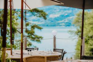 - une table avec des chaises et une vue sur le lac dans l'établissement Les Toues Cabanées du lac, à Le Sauze-du-Lac