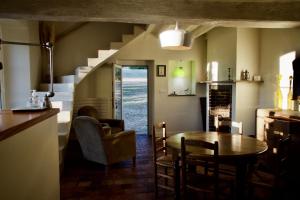 eine Küche und ein Esszimmer mit Tisch und Stühlen in der Unterkunft LA PETITE MAISON DANS LA PRAIRIE in Mézilles