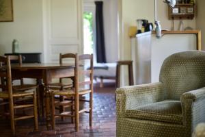 eine Küche mit Esstisch und Stühlen in der Unterkunft LA PETITE MAISON DANS LA PRAIRIE in Mézilles