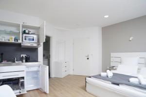 Habitación blanca con cama y microondas en Hamburg Nord Apartments en Hamburgo