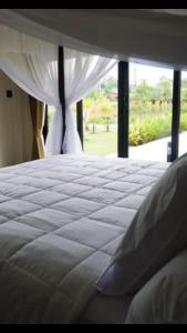 Tinna Resort في Ban Nong Mai Ngam: غرفة نوم بسرير ابيض مع نافذة