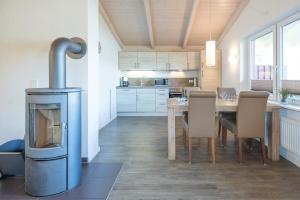 Il comprend une cuisine équipée d'une table, de chaises et d'une cuisinière. dans l'établissement Ferienhaus - Sylt, à Dagebüll
