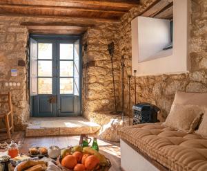 a living room with a couch and a table with fruit at 1813 Painters Stone Shelter in Galaxidi