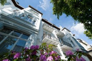 a white building with flowers in front of it at Hotel Spöttel in Bad Nauheim