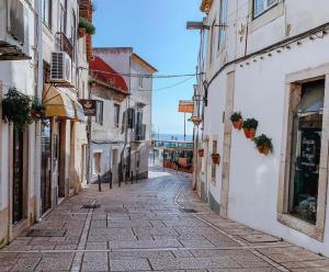 an alley in an old town with white buildings at Casa amigavel do Mar in Sesimbra