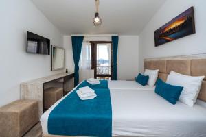 sypialnia z dużym łóżkiem z niebieską i białą pościelą w obiekcie Altea w Šušanju