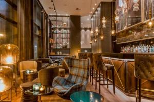 a bar with chairs and tables in a restaurant at Motel One Glasgow in Glasgow