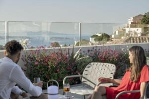 a man and a woman sitting on a balcony at Alta House Begur in Begur