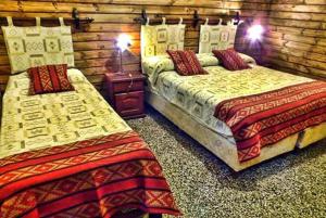 2 camas en una habitación con paredes de madera en Hotel inty raimi en Salta