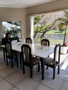 a woman sitting at a table in a restaurant at Sunset Boulevard Riverlodge in Paarl
