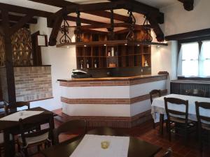 un restaurante con mesas y sillas y un bar en Agriturismo Casa Shangri-La, en San Giovanni al Natisone