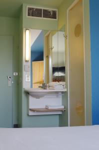 
a bathroom with a sink and a mirror at ibis budget Narbonne Est in Narbonne
