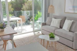 a living room with a couch and a table at Apartment Sa Calobra with pool & terrace in Canyamel in Capdepera