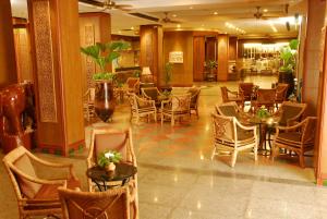 a lobby with chairs and tables in a building at Golden Beach Hotel Pattaya in Pattaya