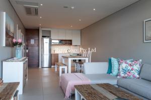 a living room with a couch and a kitchen at Gorgeous 1 Bed Zimbali Suites Sea View in Ballito