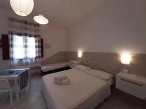 1 dormitorio con cama blanca y sofá en Il Cortile Di Eolo, en Marettimo