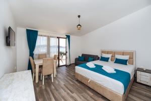 1 dormitorio con cama, mesa y sofá en Altea, en Šušanj