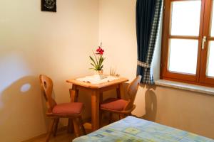 フィルツモースにあるHallmooshofの小さなテーブルと椅子、花瓶