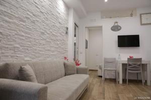 - un salon avec un canapé et un mur en briques dans l'établissement La Tradizione, à Bari