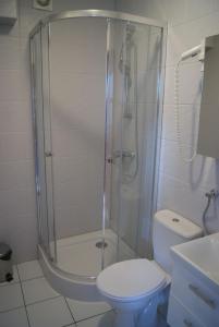 een badkamer met een douche, een toilet en een wastafel bij Hotel Wodnik Twój Hotel z widokiem na morze in Ustronie Morskie