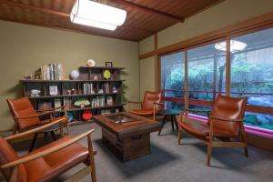 a living room with chairs and a table and a window at Tsukihitei in Nara