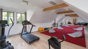a gym with treadmills and exercise equipment in a attic at Castel Maintenon Hôtel Restaurant & Spa in Maintenon