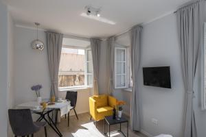 Sala de estar con silla amarilla y mesa en Apartments Urbis, en Dubrovnik