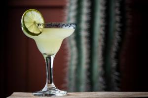 a drink in a glass with a lime on a table at Vincci EverEden in Anavyssos