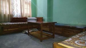 een kamer met twee bedden en een tafel erin bij Vamoose Himalayan Viewpoint in Ravangla