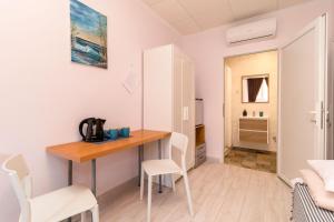 Habitación pequeña con mesa de madera y sillas. en Hostal 7A, en Torrevieja