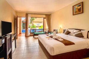 Pokój hotelowy z dużym łóżkiem i telewizorem w obiekcie New Sunari Lovina Beach Resort w mieście Lovina