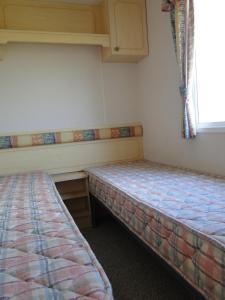 two beds sitting in a room with a window at Lary Camping Homes - Domki Gorzewo in Gostynin
