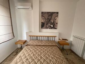 a bedroom with a bed with two tables and a painting at Finestra sui Ponti in Ragusa