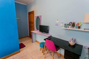 Zimmer mit einem Schreibtisch mit einem Computer und rosa Stühlen in der Unterkunft Evening Sun B&B in Green Island