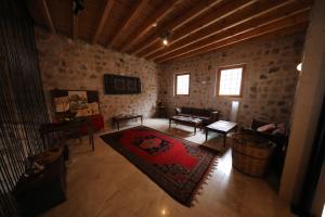 a living room with a couch and a rug at Helike Cave Suites in Uchisar