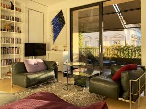 ein Wohnzimmer mit 2 Ledersesseln und einem TV in der Unterkunft Casa Terrazza Colosseo in Rom