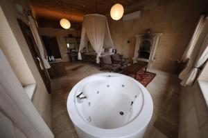 a bathroom with a bath tub and a living room at Helike in Cappadocia in Uchisar