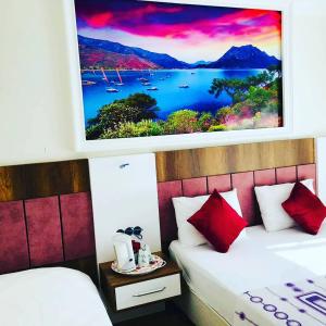 a hotel room with two beds and a painting on the wall at Arikanda River Garden Hotel in Adrasan