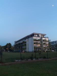 a large building with a field in front of it at Ezüst Apartman in Siófok