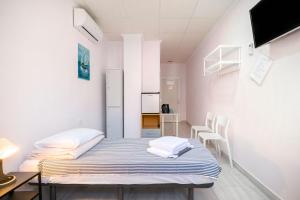 um pequeno quarto com uma cama, uma mesa e cadeiras em Hostal 7A em Torrevieja