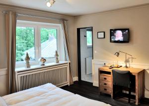 a bedroom with a bed and a desk and a window at Hotel und Landhaus 'Kastanie' in Hamburg