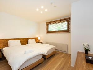 a bedroom with two beds and a window at Birchwood Chalet in Niseko